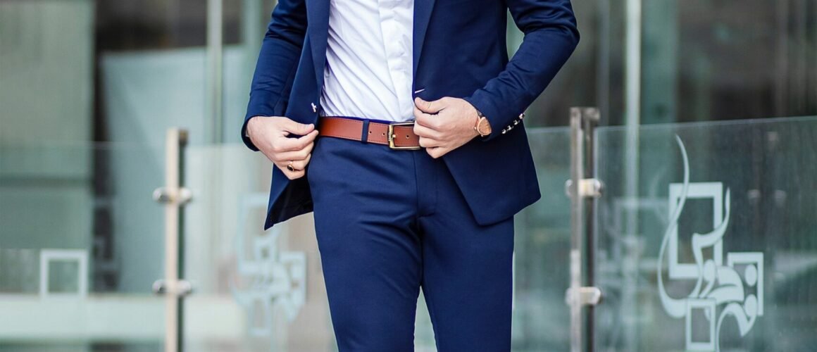 man in blue suit standing on sidewalk during daytime